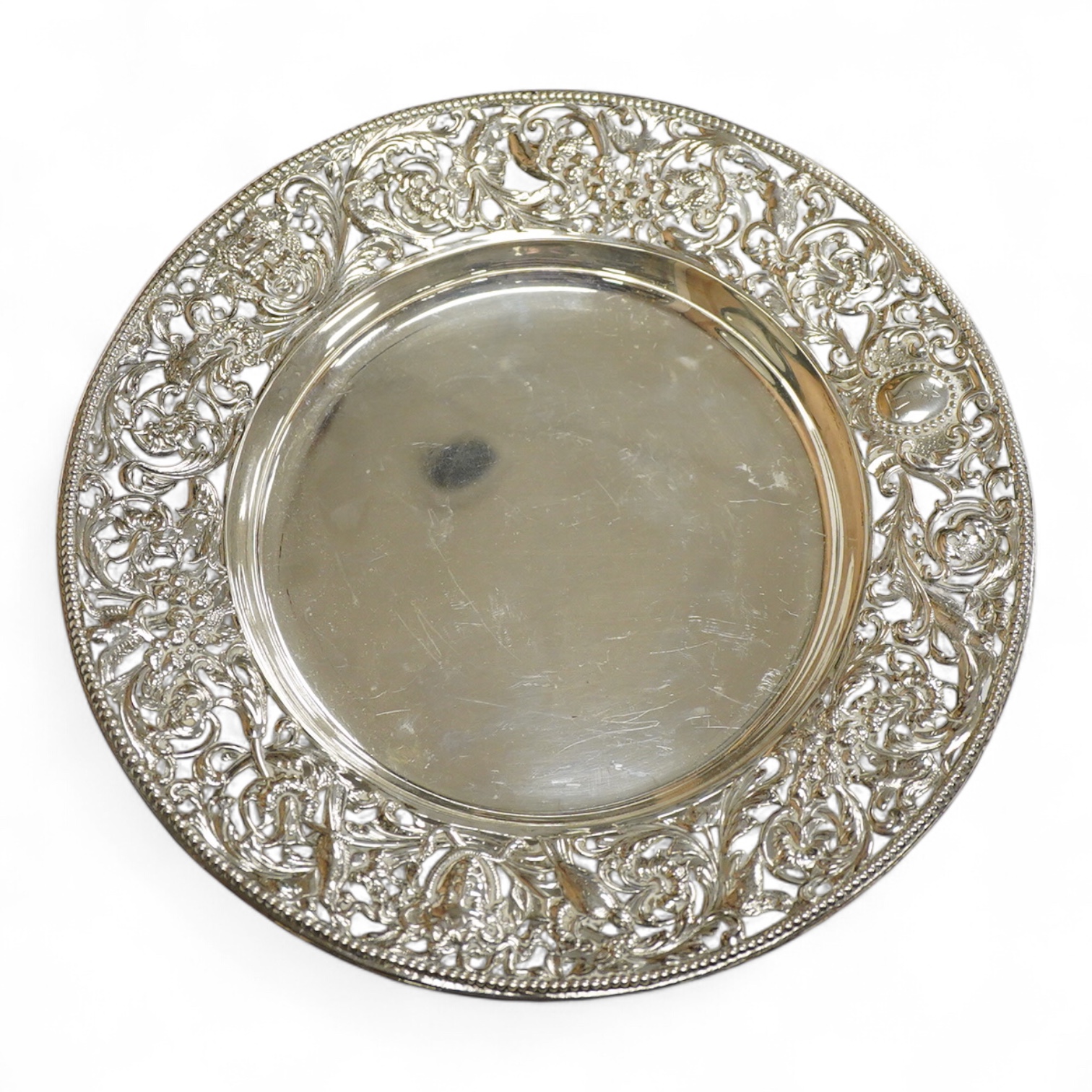 A late Victorian shallow dish or stand, by William Comyns, with pierced foliate border, decorated with masks and birds, London, 1898, diameter 23.1cm, 11.4oz.